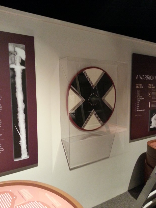 The shield mounted on the wall next to the Grave 2 plinth